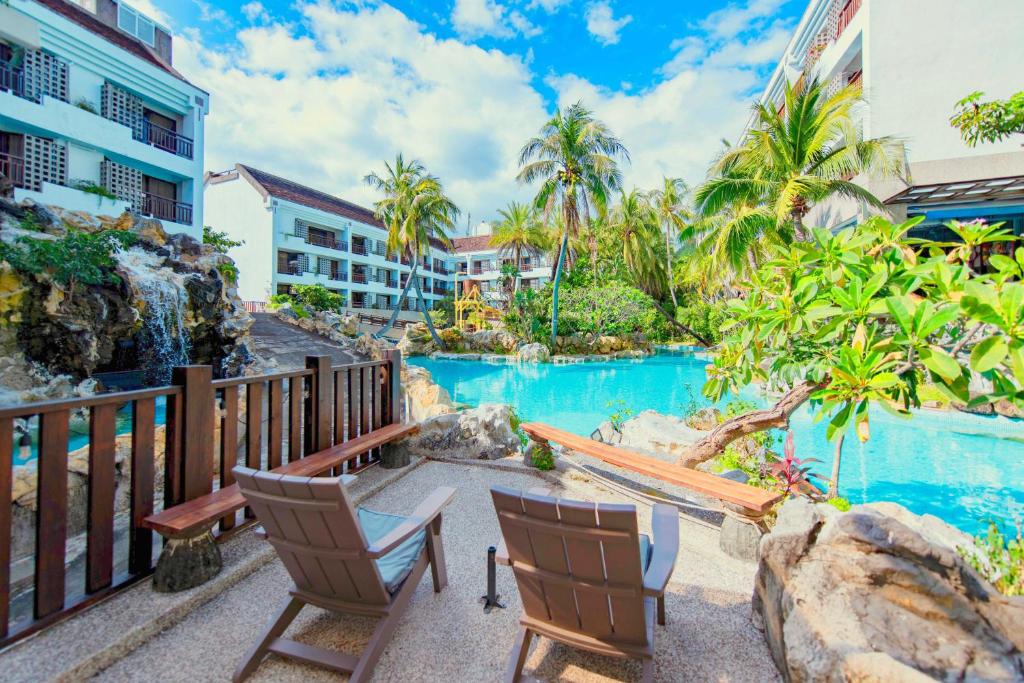 a resort with a swimming pool and two chairs at Yoho Beach Resort Kenting in Hengchun