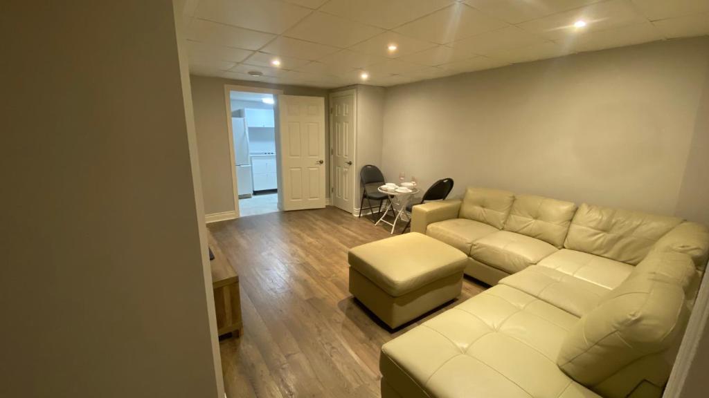 Una sala de estar con un sofá blanco y una mesa. en Cozy Basement, en Richmond Hill