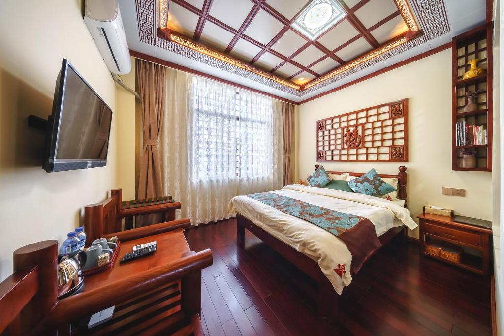 - une chambre avec un lit et une télévision dans l'établissement Dali Classical Rosewood Boutique Inn, à Dali
