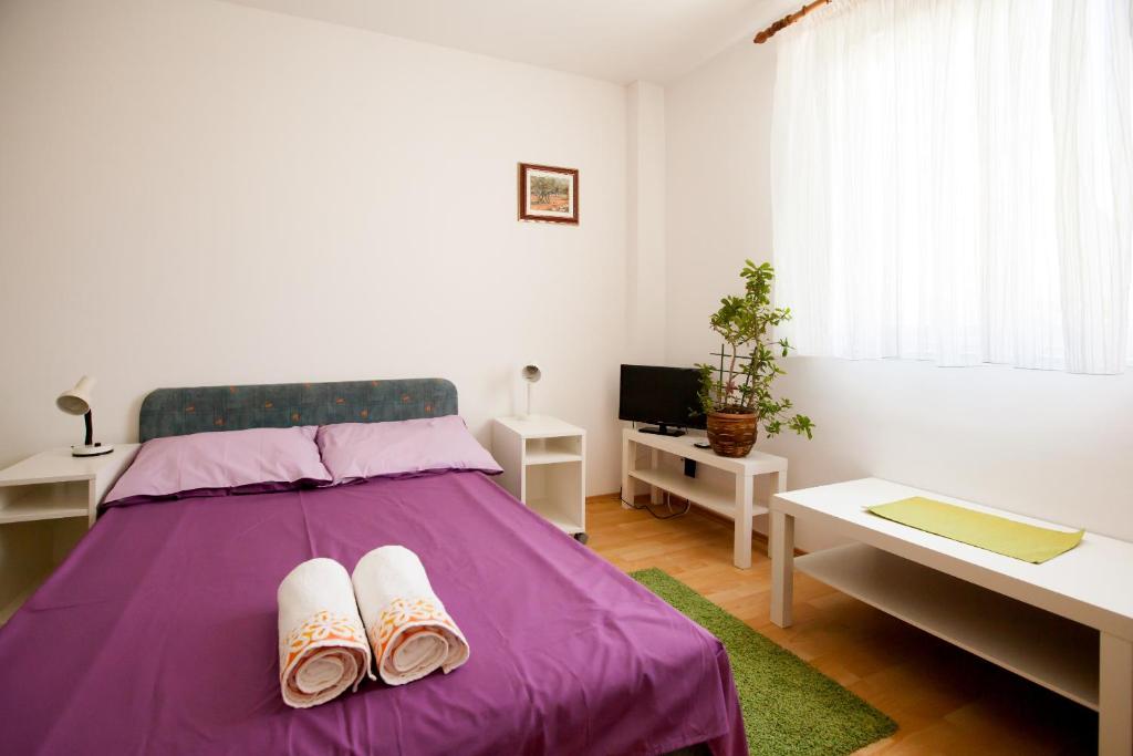 Un dormitorio con una cama morada con chanclas. en Friendly People's Guest House, en Zadar