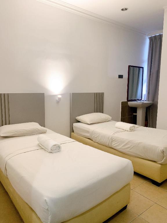 Postel nebo postele na pokoji v ubytování One Stop Hotel Ipoh