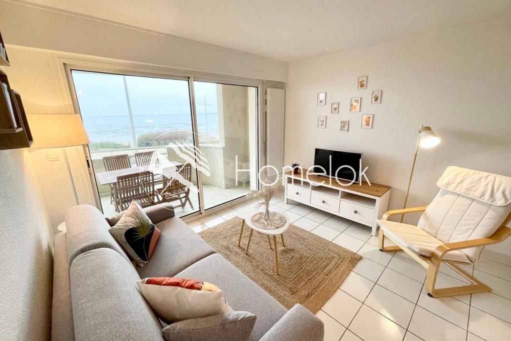un salon avec un canapé et une télévision dans l'établissement Splendide T2 Archi Cocooning Vue mer 180, à Ploemeur