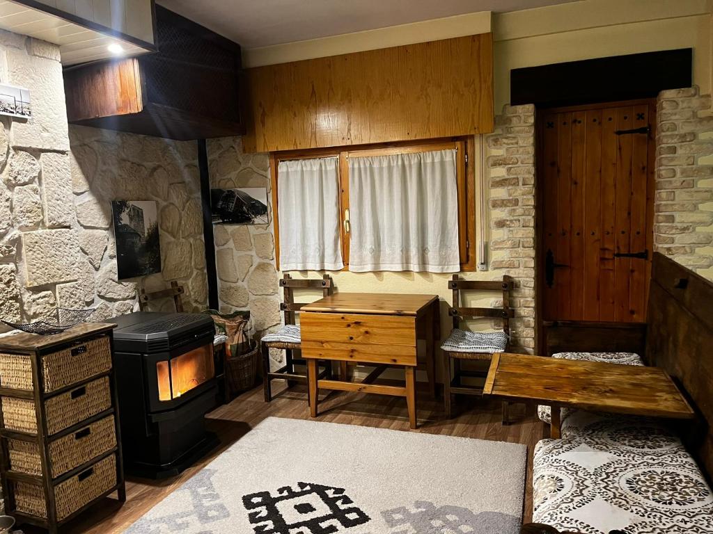 ein Wohnzimmer mit einem Holzofen und einem Tisch in der Unterkunft Apartamento Selva Blanca 9 in Villanúa