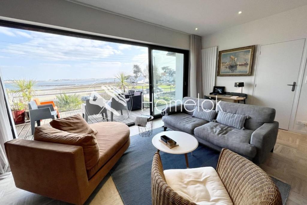 un salon avec un canapé et une table dans l'établissement Luxury T3 neuf de standing Front de mer vue 180, à Larmor-Plage