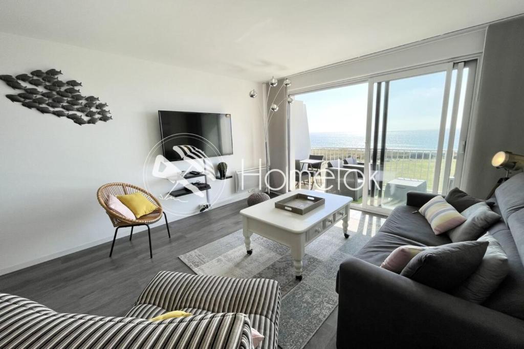 un salon avec un canapé et une table dans l'établissement Magnifique T2 archi cosy Vue mer 180 Piscine, à Guidel