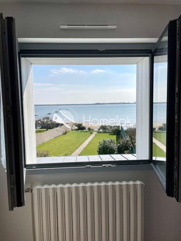 une fenêtre avec vue sur l'océan dans l'établissement Maison de charme vue mer 180 rénovée Accès plage, à Riantec