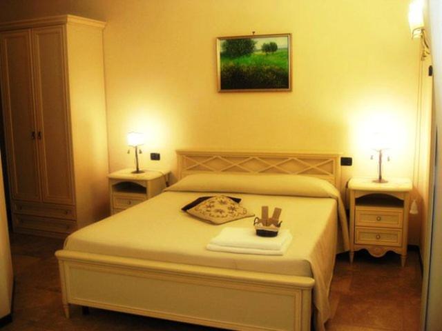 a bedroom with a white bed with two night stands at B&B La Dimora Di Nettuno in Naples