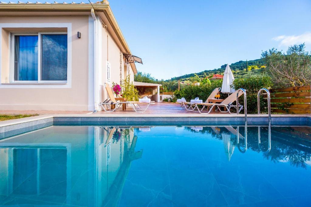 eine Villa mit einem Swimmingpool vor einem Haus in der Unterkunft Villa Mazzeto Casa Alonia in Áno Yerakaríon