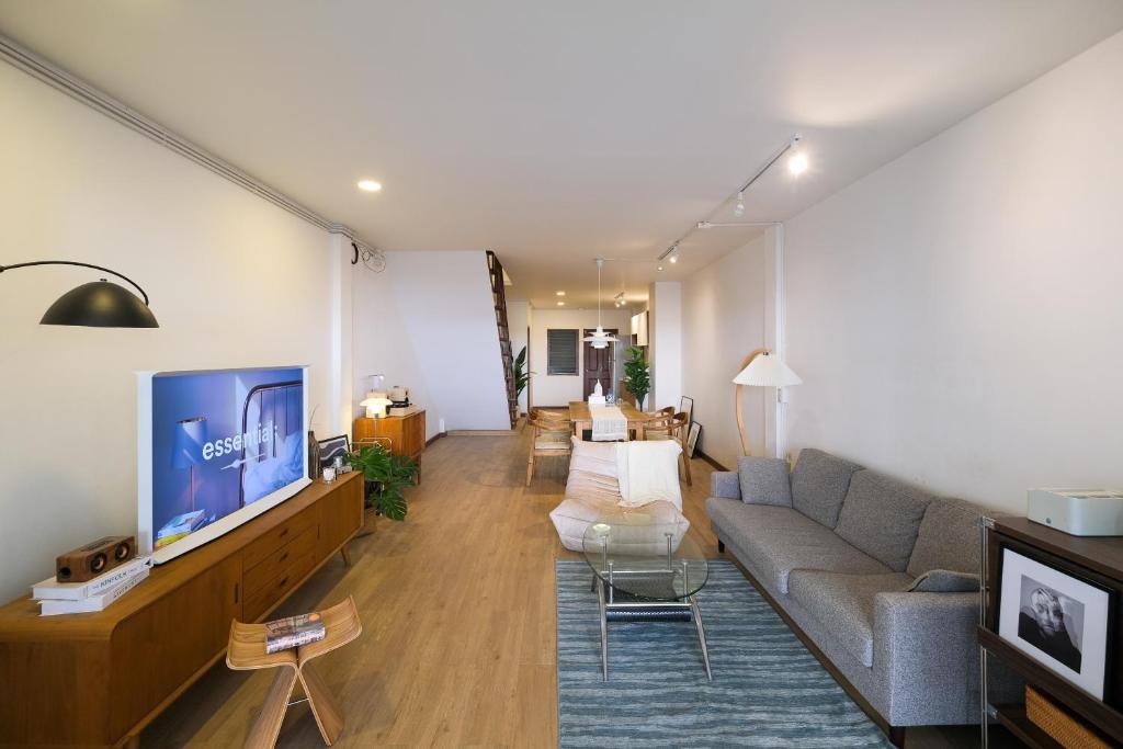 Una sala de estar con un sofá y un televisor. en Wit Haus Nimman, en Chiang Mai