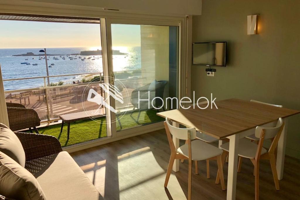 Un comedor con mesa y vista al mar. en Magnifique duplex super cosy Vue mer 180, en Ploemeur
