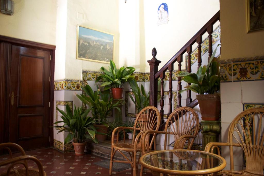 a room with chairs and a staircase with plants at Pensión Matilde in Granada