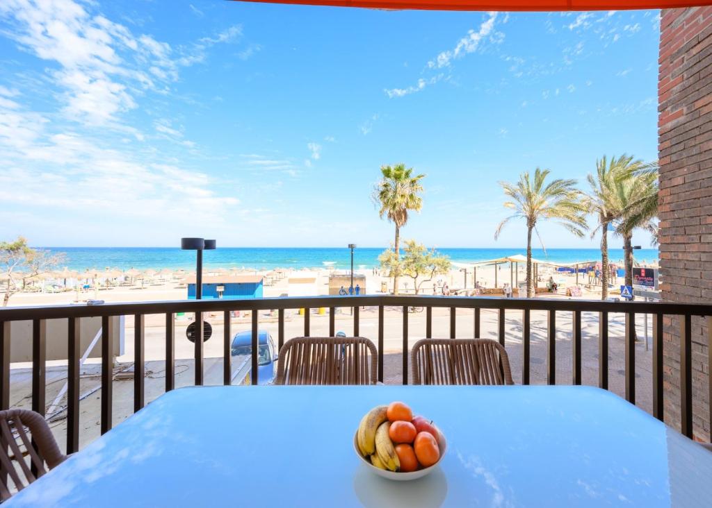 a table with a bowl of fruit on a balcony overlooking the beach at La Paz by 10toSea in Fuengirola
