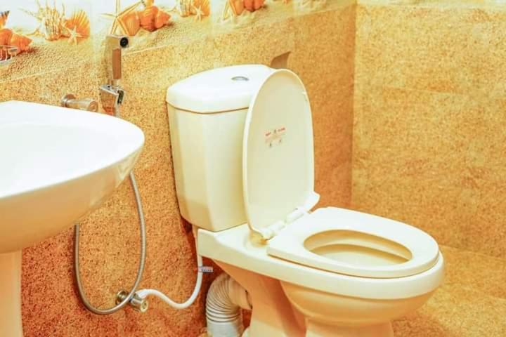 a bathroom with a toilet and a sink at Riyon Rooms and Restaurant in Weligama