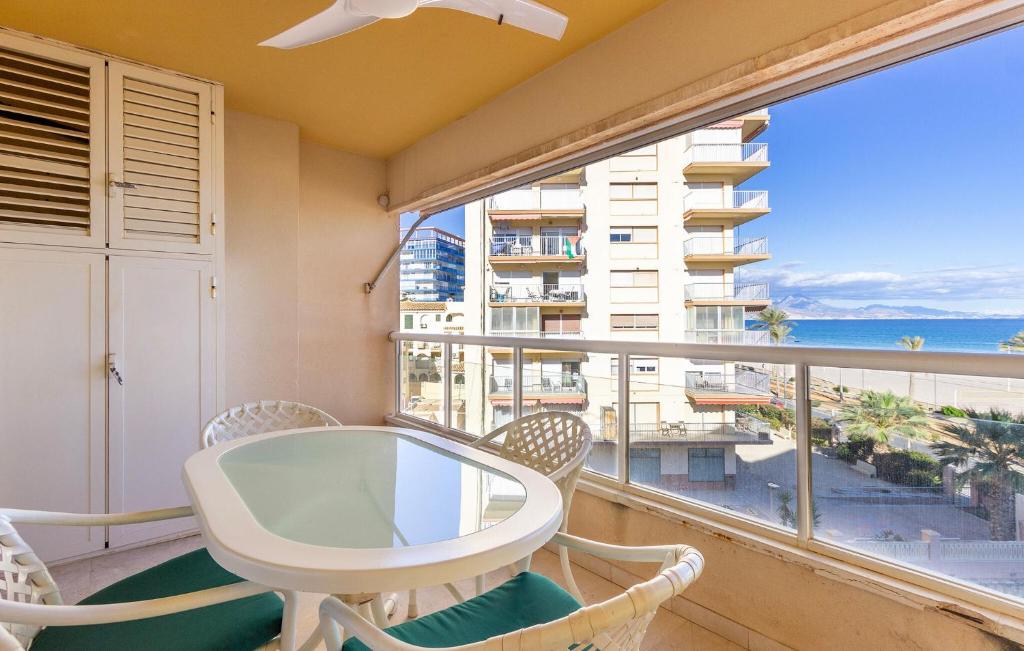 ein Balkon mit Tisch und Stühlen und einem großen Fenster in der Unterkunft Pet Friendly Apartment In El Campello in El Campello