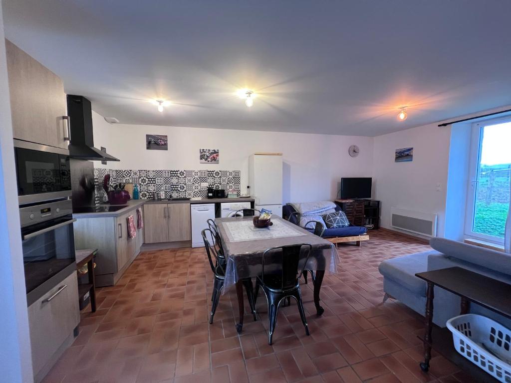 une cuisine et un salon avec une table et des chaises dans l'établissement Location à la campagne, à Saint-Mars-de-Locquenay