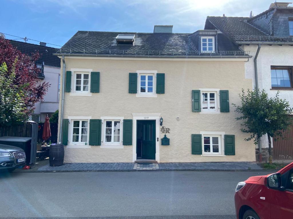 a large house with green shutters on a street at Eifeloase in Birresborn