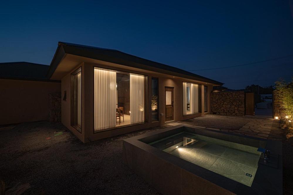 a house with a swimming pool at night at Generous Jeju in Jeju