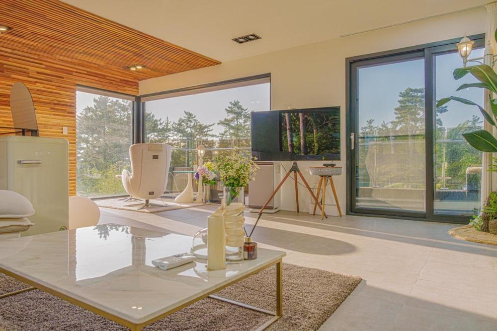 a living room with a table and a tv at By Hanlim in Jeju