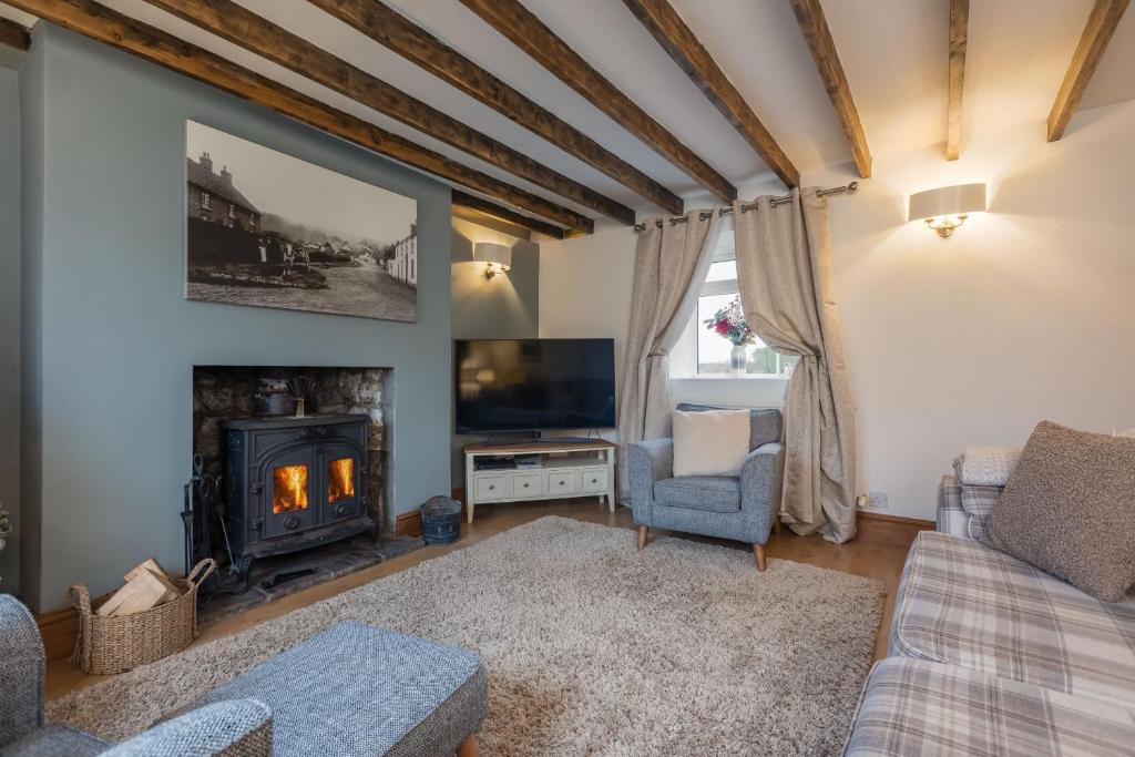 un salon avec une cheminée et une télévision dans l'établissement The Old Farm Shop, à Scarborough