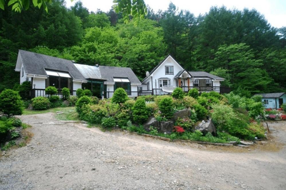 平昌郡にあるSmall Village Pensionの茂みと木々が多い家