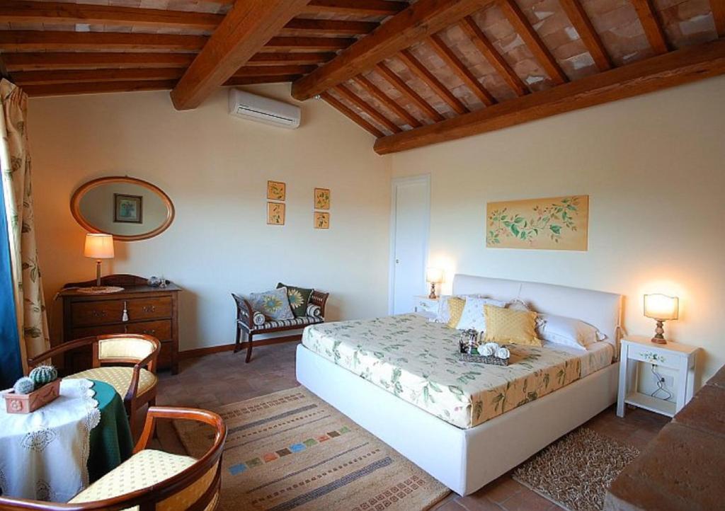 a bedroom with a bed and a table and chairs at Green House - Blue House in Civitella dʼAgliano