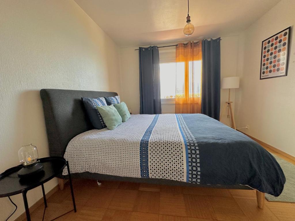 Un dormitorio con una cama y una mesa y una ventana. en Appartement Montreux au bord du lac, en Montreux