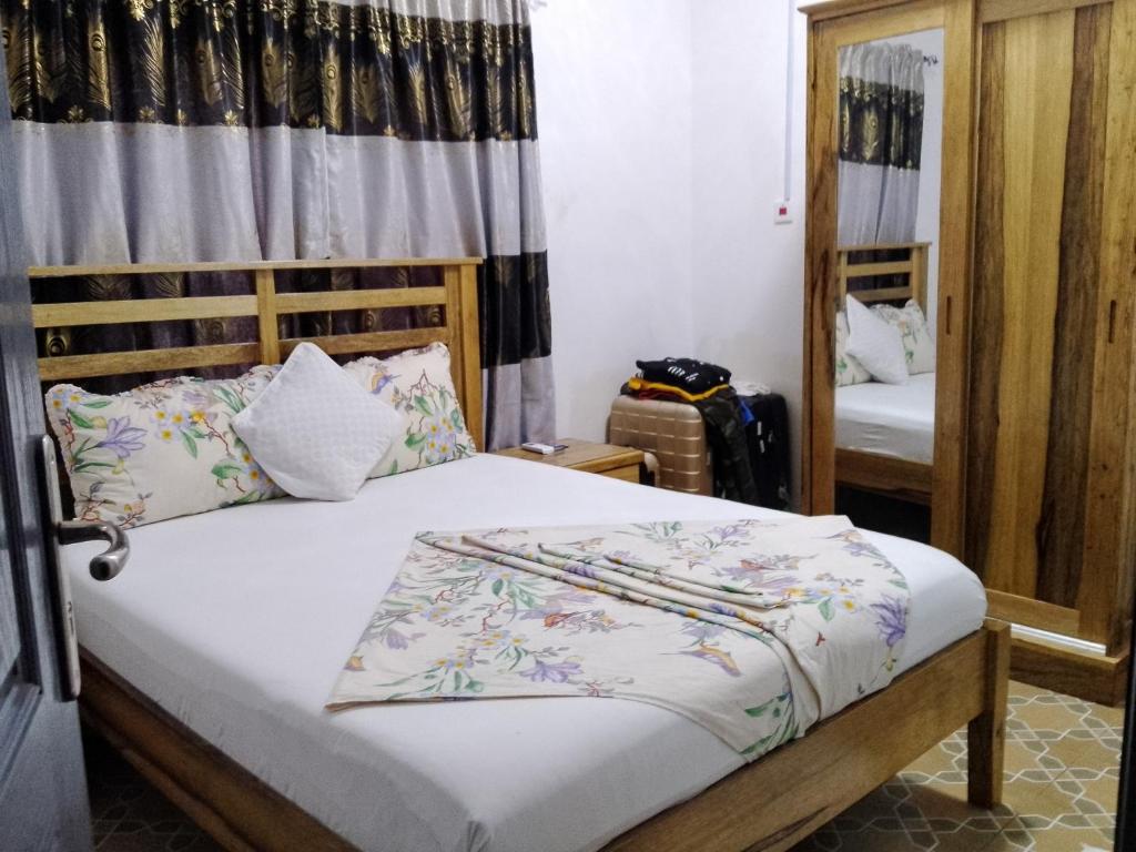 a bedroom with a bed and a mirror at BARAKAH ESTATE APARTMENTS in Sere Kunda