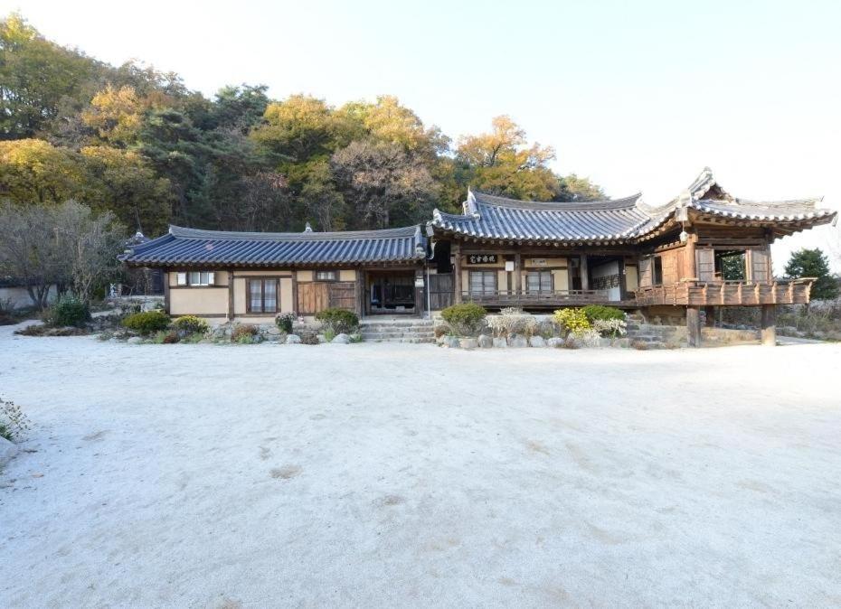 una casa con un tetto cinese in un campo di Manhoe Gotaek a Bonghwa