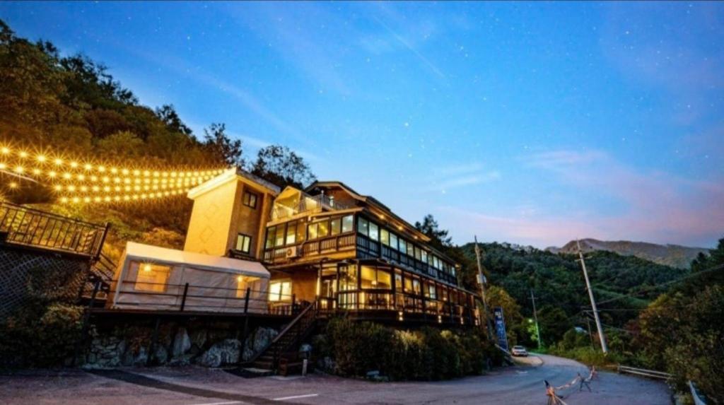a large building with lights on the side of it at Gapyeong Pop Pension in P'yŏngban-ni