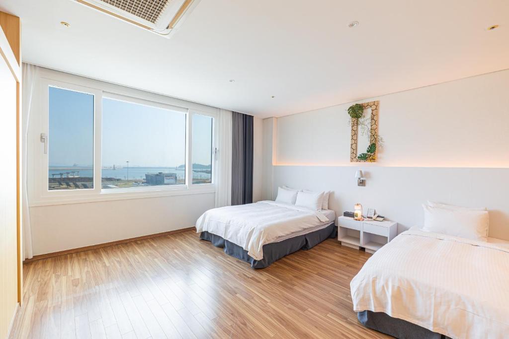 Postel nebo postele na pokoji v ubytování Yeosu Staythedelight Hotel