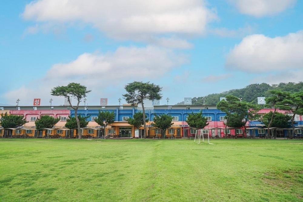 a park with a soccer field in front of a building at Sungbochon Youth Hostel - Hostel in Mungyeong