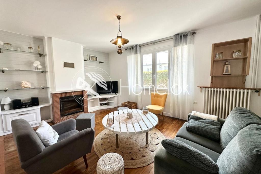 un salon avec deux canapés et une table dans l'établissement Maison de pêcheur - À 200m de la plage, à Ploemeur