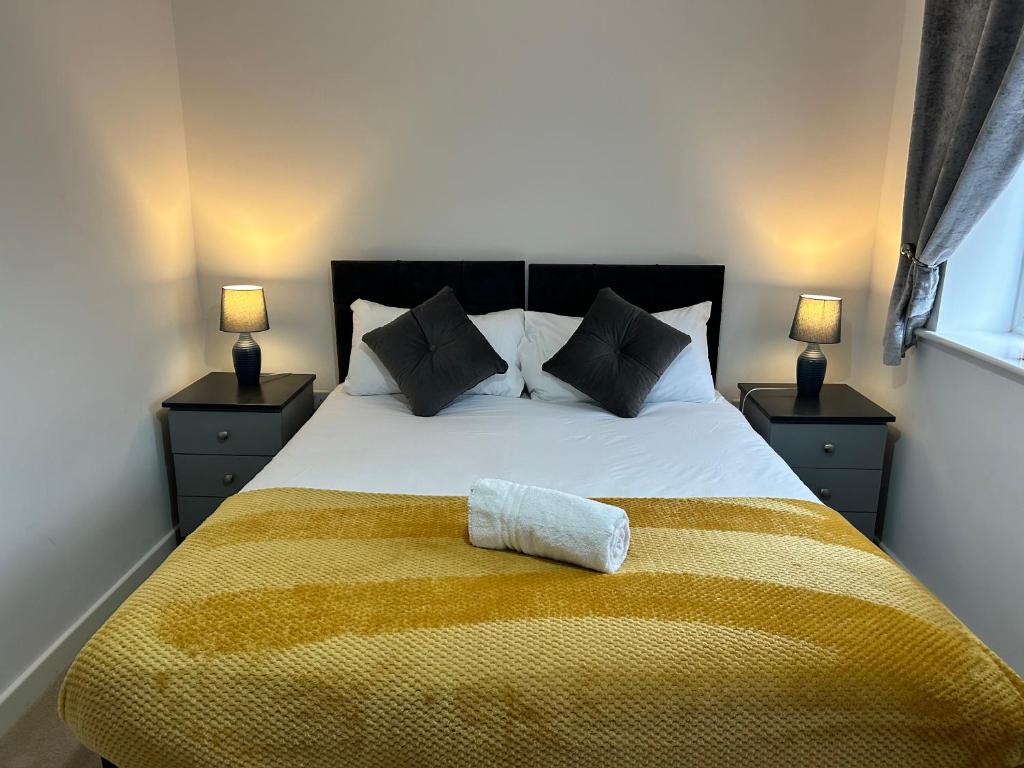 ein Schlafzimmer mit einem großen Bett mit einer gelben Decke in der Unterkunft Kingsway House - Spacious 4 Bed Home From Home in Derby in Derby