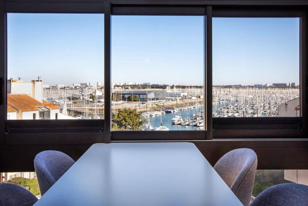 einen Tisch und Stühle in einem Zimmer mit Blick auf den Yachthafen in der Unterkunft La Misaine, les Minimes, LR117 in La Rochelle