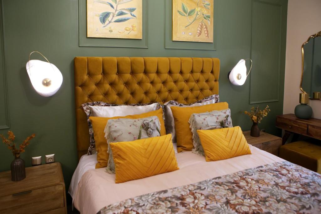 a bedroom with a large bed with yellow pillows at Χρυσηίδα - Chrysiida Luxury Apartment in Nafplio