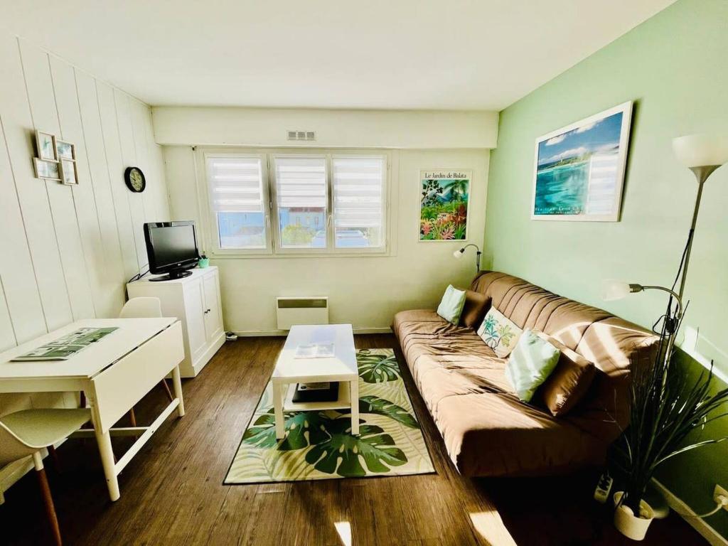 un salon avec un canapé et une table dans l'établissement Le Guiton - Parking Wifi, à La Rochelle