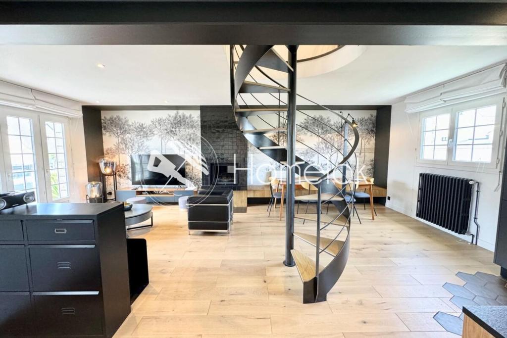 Una sala de estar con una escalera de caracol en el medio. en Luxury Magnifique Villa d architecte Cocooning, en Larmor-Plage