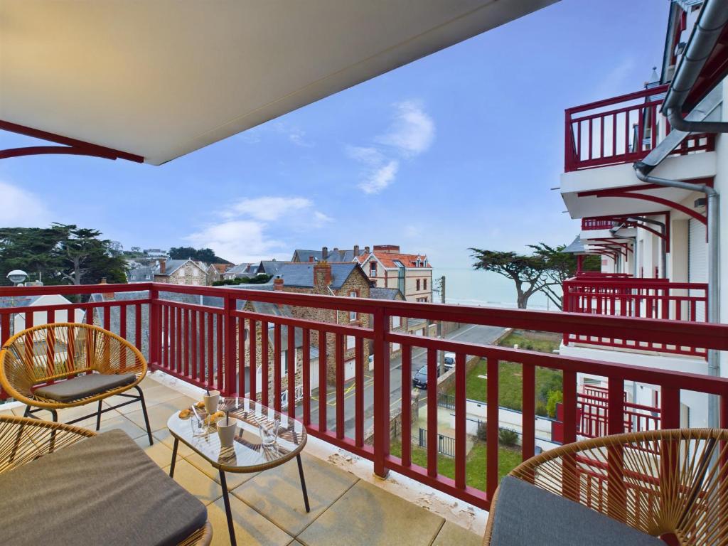 un balcon avec des chaises et une table et une vue dans l'établissement Vue sur mer et plage, appartement pour 4, à Pléneuf-Val-André