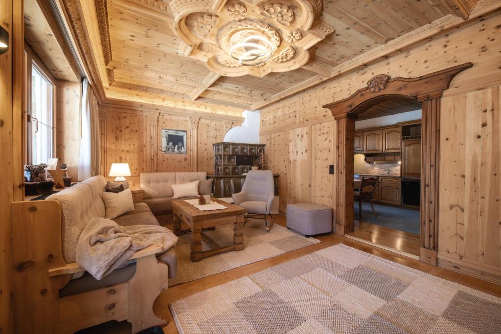 a living room with a couch and a chandelier at Ferienwohnung Zirbenglück- Wellness inklusive in Fulpmes