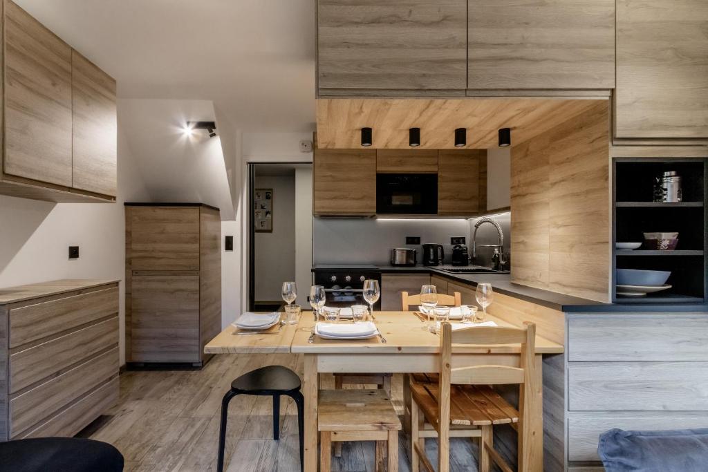 une cuisine avec une table en bois et une salle à manger dans l'établissement Kinabalu - Vue Mt Blanc Range Les houches center, aux Houches