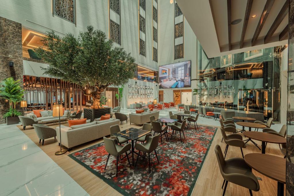 eine Lobby mit Tischen und Stühlen in der Unterkunft Millennium Al Masar in Dschidda