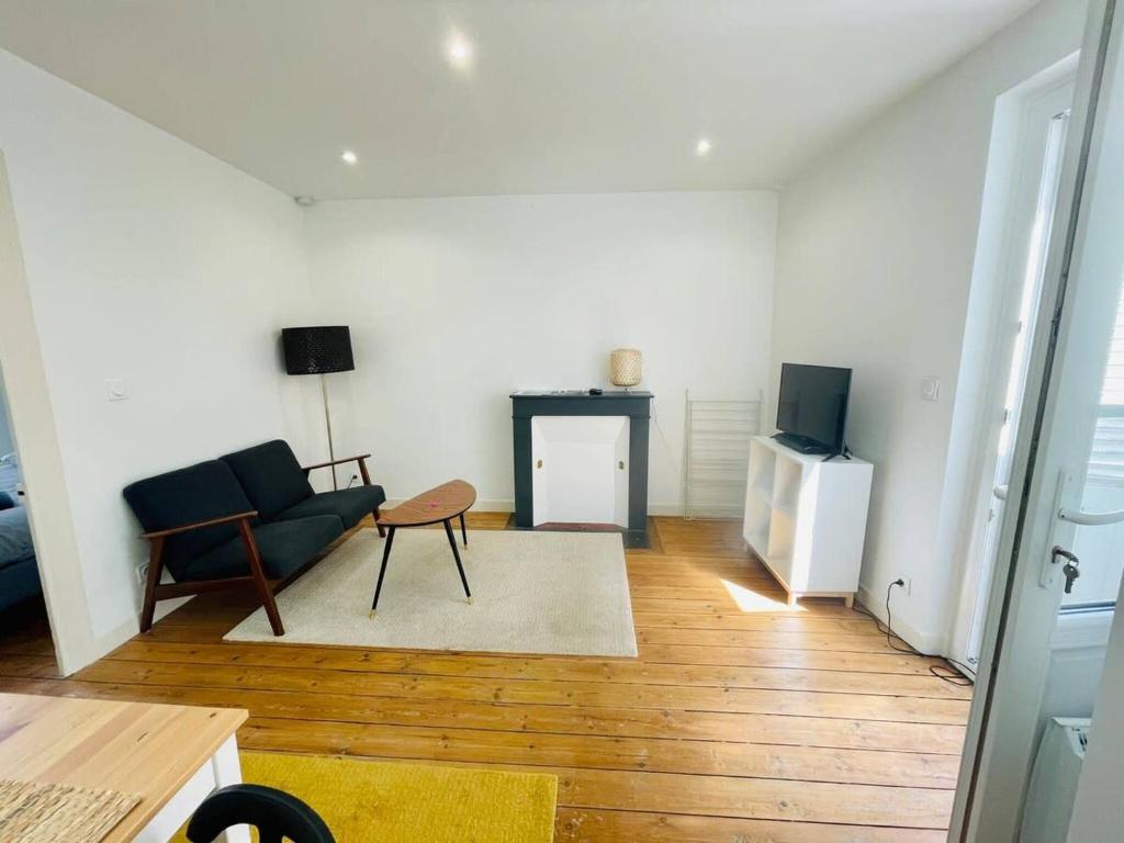 un salon avec un canapé et une télévision dans l'établissement Le Templiers avec Terrasse - Hyper Centre Lr, à La Rochelle