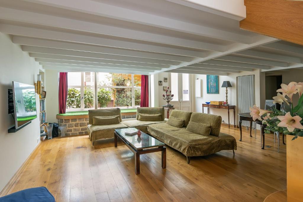 un salon avec un canapé et une table dans l'établissement Louvre Apartments, à Paris