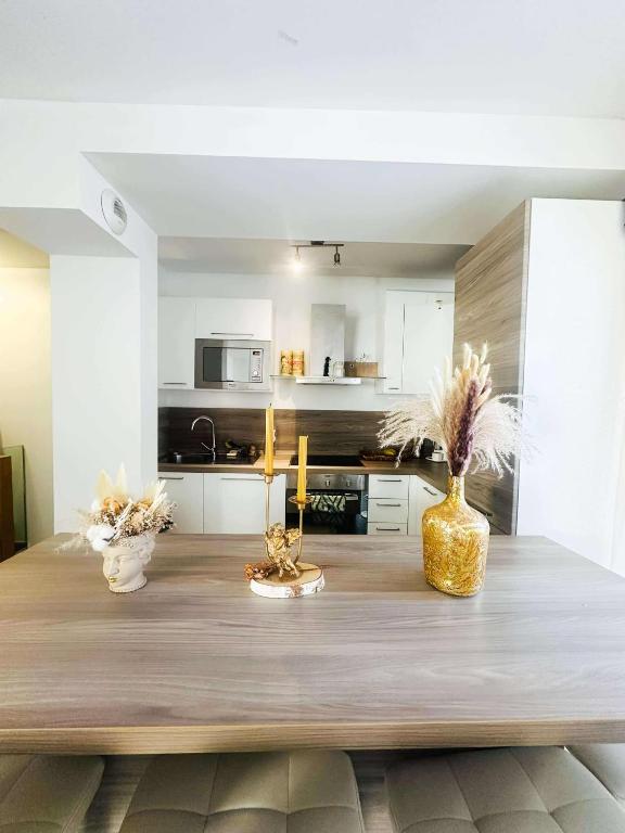 - une cuisine avec une table en bois et 2 vases dans l'établissement Bel appartement proche de la mer, à Monticello