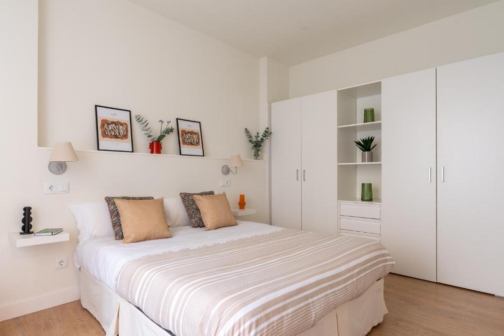 a white bedroom with a bed with white walls at Sweet Home Santander in Santander