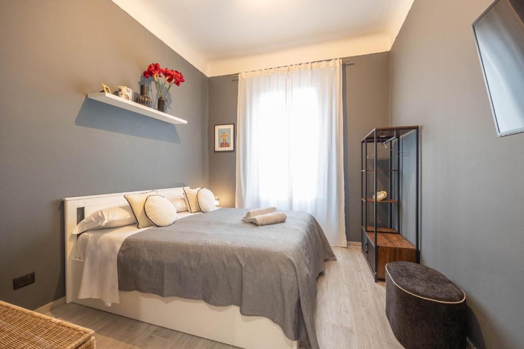 Un dormitorio con una cama con almohadas y una ventana. en Moderne Maison Ariston, en San Remo