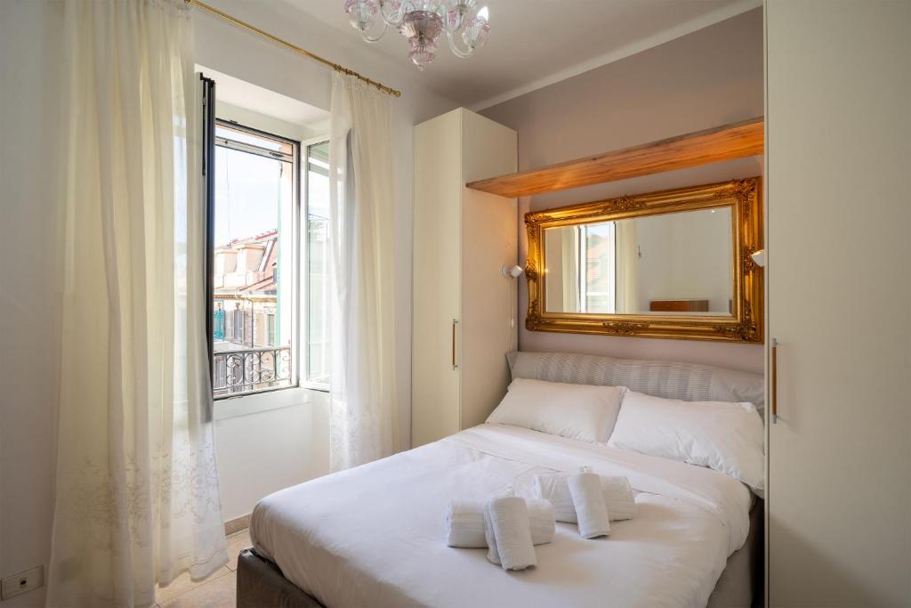a bedroom with a bed with a mirror and a window at Gioberti Flat - WiFi - City Center - Shopping Street - Casino - Ariston in Sanremo