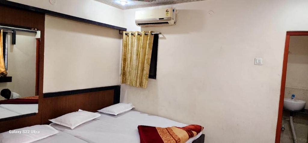 Postel nebo postele na pokoji v ubytování Hotel Sai Murlichandra Shirdi