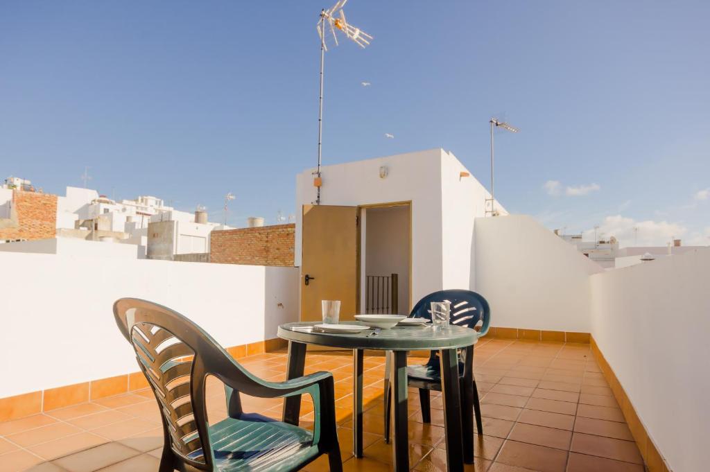uma varanda com uma mesa e cadeiras num telhado em Apartamento Junquera em Conil de la Frontera
