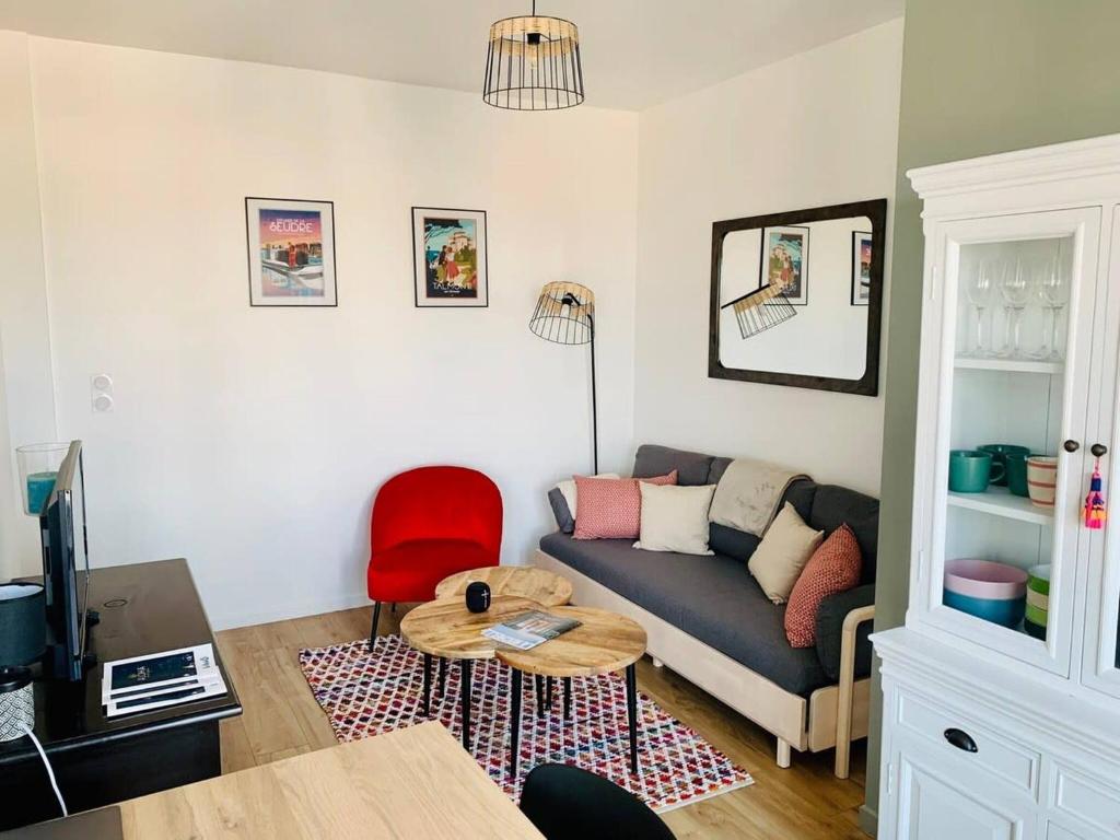 un salon avec un canapé et une table dans l'établissement Le Treich Laplene - Parking Wifi, à La Rochelle